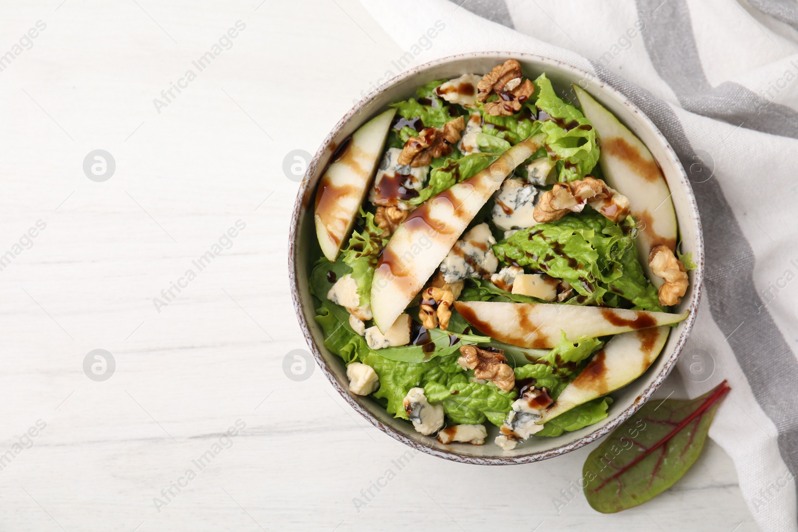 Photo of Delicious pear salad with sauce in bowl on light table, top view. Space for text