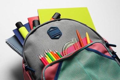 Photo of Backpack with different school stationery on white background