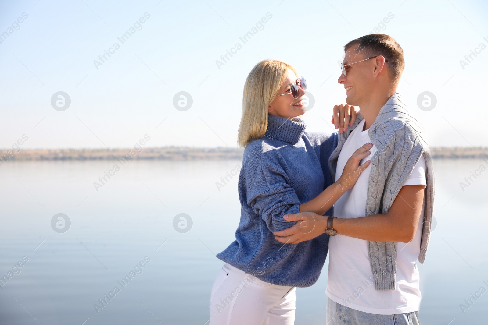 Photo of Happy couple in stylish sweaters on beach