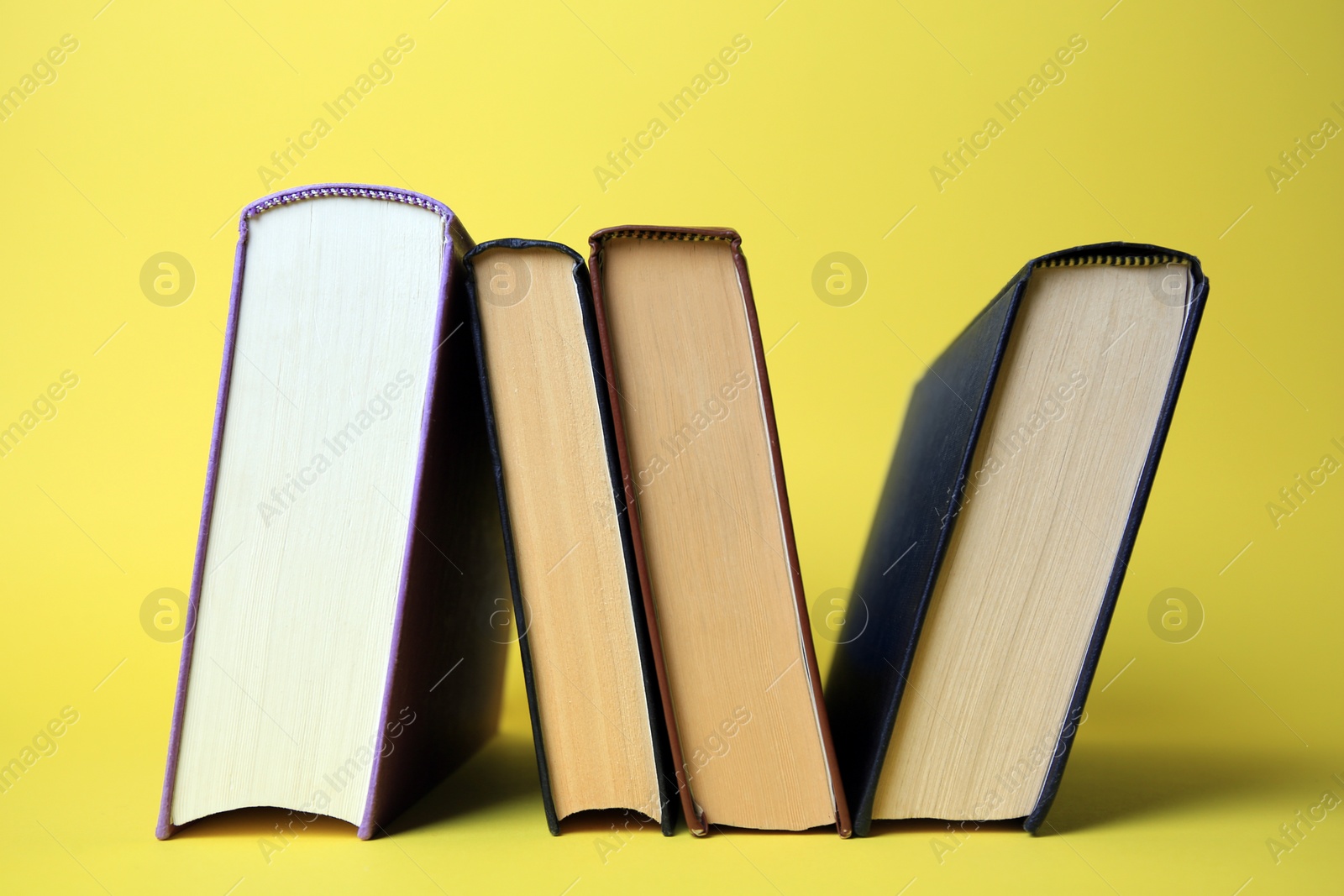 Photo of Collection of hardcover books on yellow background