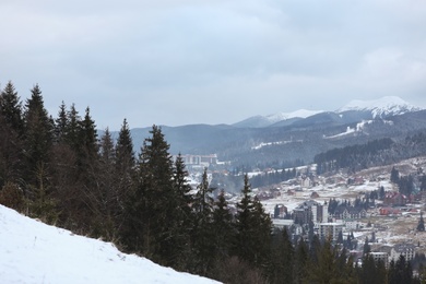 Photo of Winter landscape with mountain village near conifer forest