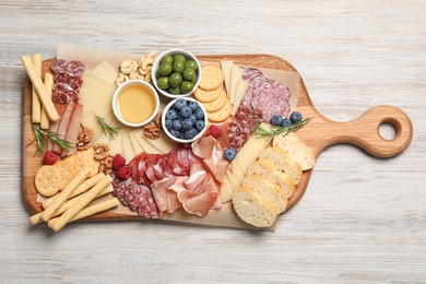Photo of Tasty parmesan cheese and other different appetizers on white wooden table, top view