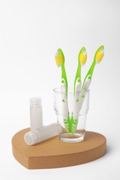 Colorful toothbrushes and cosmetic products on white background