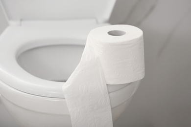 Paper roll on toilet bowl in bathroom, closeup