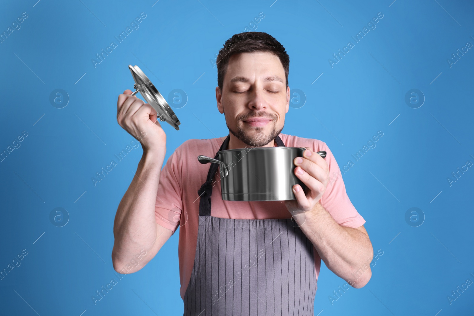 Photo of Happy man with pot on light blue background