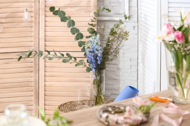 Decorator's workplace with beautiful flowers on table