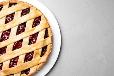 Photo of Delicious fresh cherry pie on light grey table, top view. Space for text