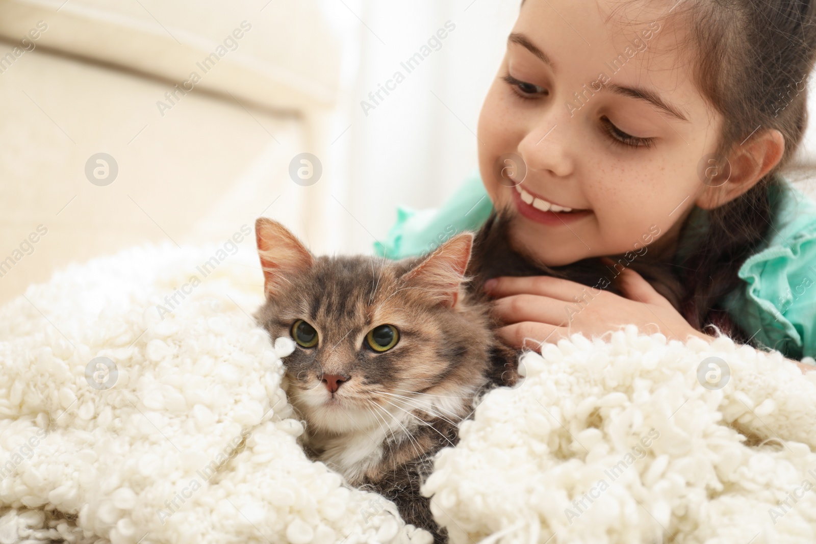 Photo of Cute little girl with cat lying at home. First pet