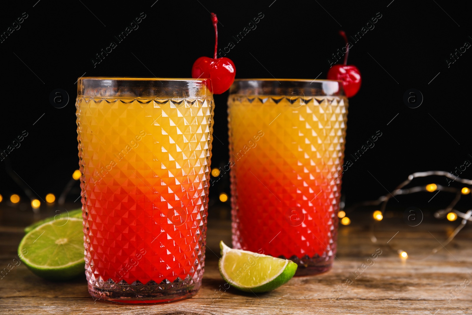 Photo of Fresh alcoholic Tequila Sunrise cocktails on wooden table