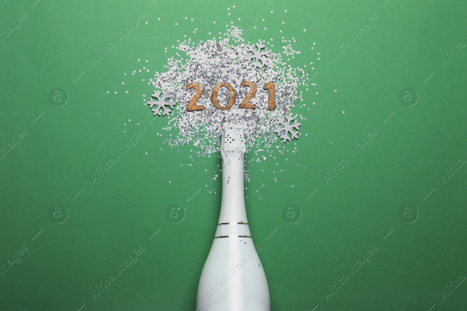 Photo of Year number 2021, bottle with champagne and shiny confetti on green background, flat lay