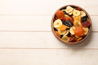 Photo of Mix of delicious dried fruits on white wooden table, top view. Space for text