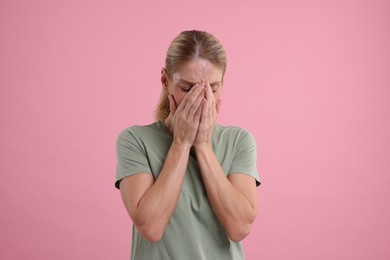 Photo of Resentful woman covering face on pink background