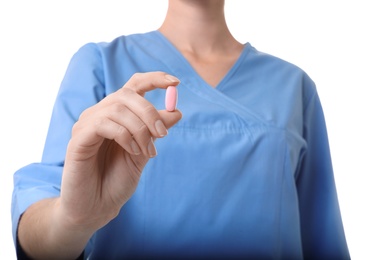 Photo of Female doctor holding pill on white background, closeup. Medical object