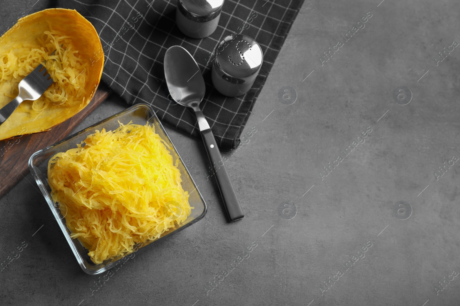 Photo of Flat lay composition with cooked spaghetti squash and space for text on grey table