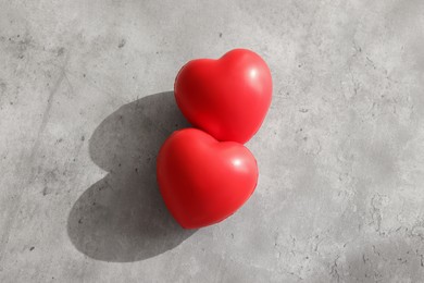 Photo of Two decorative hearts on gray textured table, top view