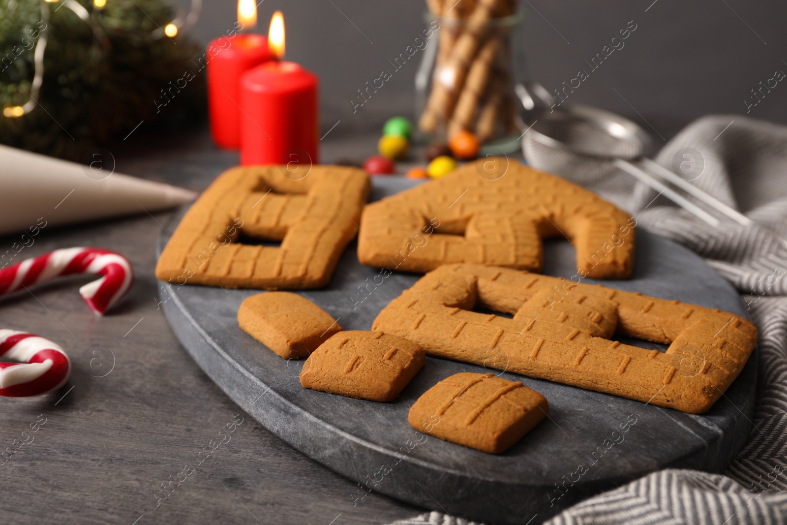 Photo of Parts of gingerbread house on grey table, closeup