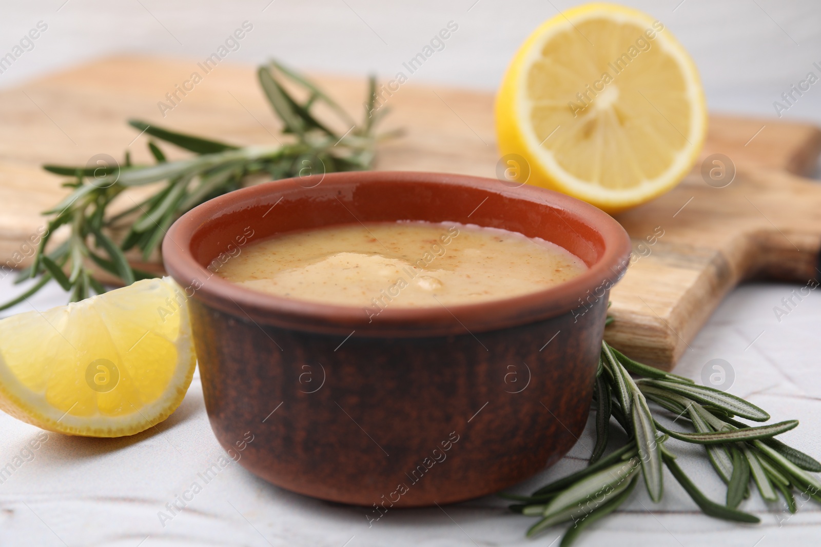 Photo of Delicious turkey gravy, rosemary and lemon on table, closeup