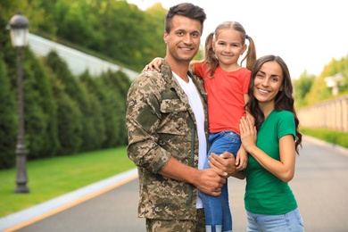 Man in military uniform with his family  at sunny park