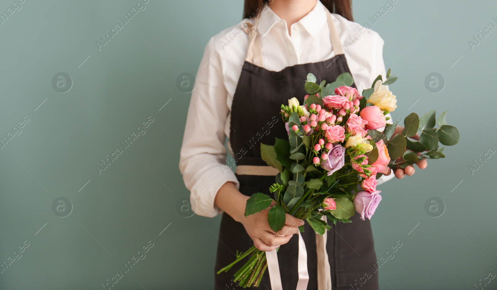 Photo of Female florist with beautiful bouquet on color background