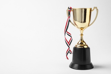 Photo of Shiny golden trophy cup on white background