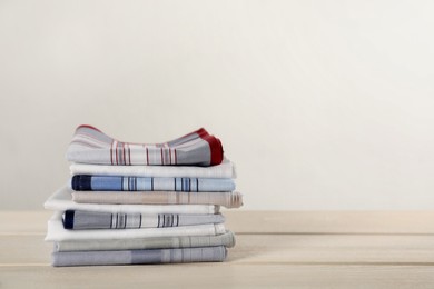 Photo of Stack of stylish handkerchiefs on white wooden table, space for text