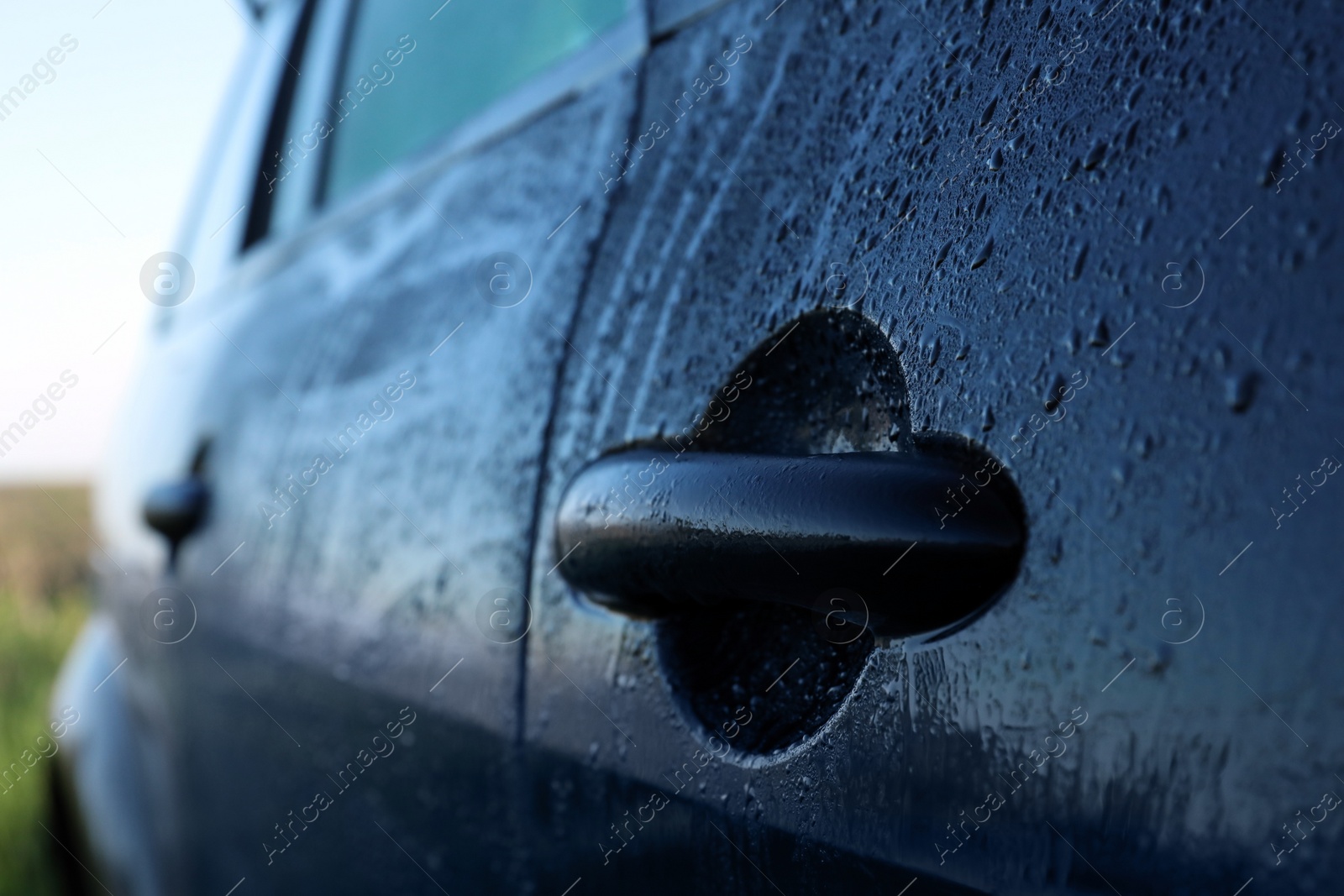 Photo of Wet car with door handle outdoors, closeup view