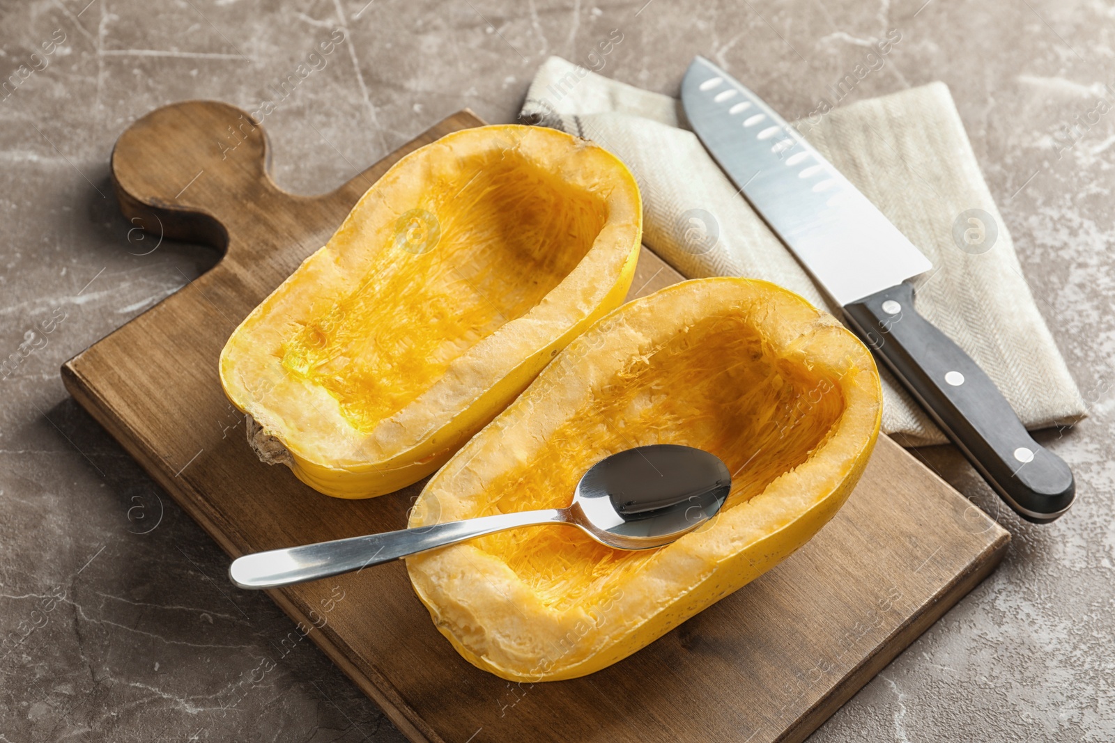 Photo of Wooden board with cut spaghetti squash on table