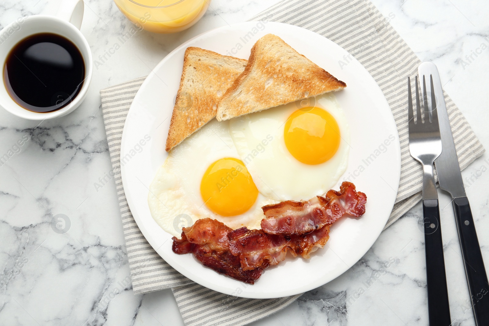 Photo of Delicious breakfast with sunny side up eggs served on white marble table, flat lay