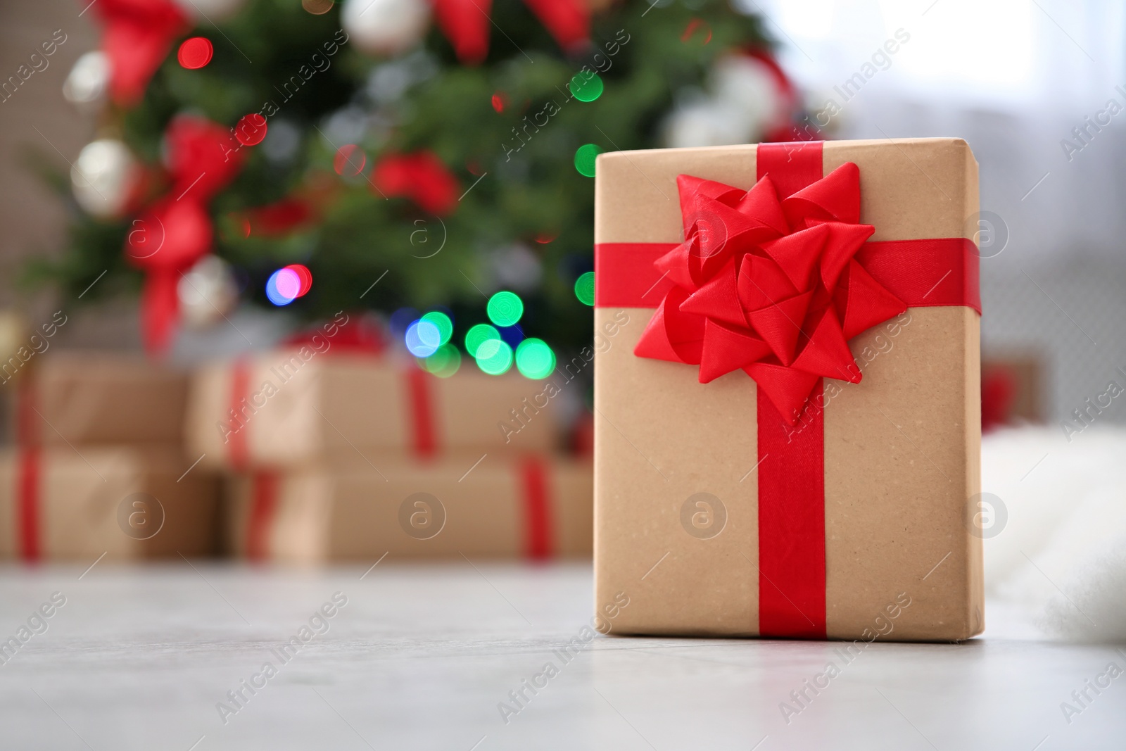 Photo of Gift box and blurred Christmas tree on background
