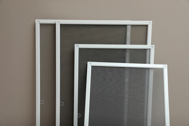 Set of window screens near beige wall