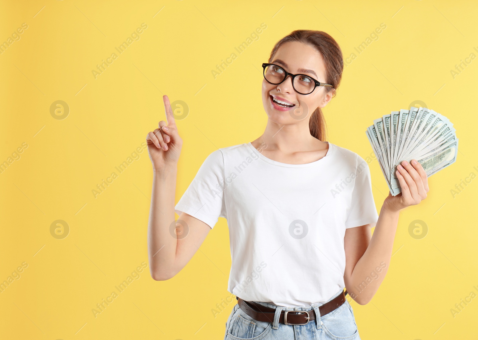 Photo of Young woman with money on yellow background