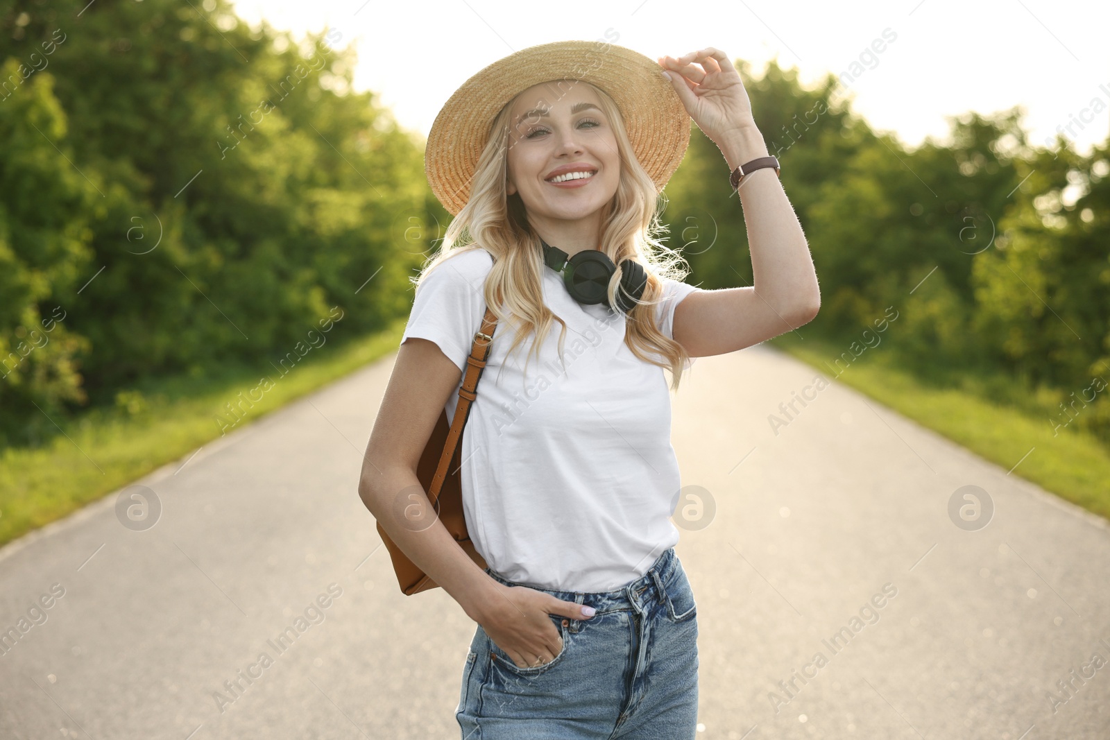 Photo of Happy young woman with headphones in park on spring day