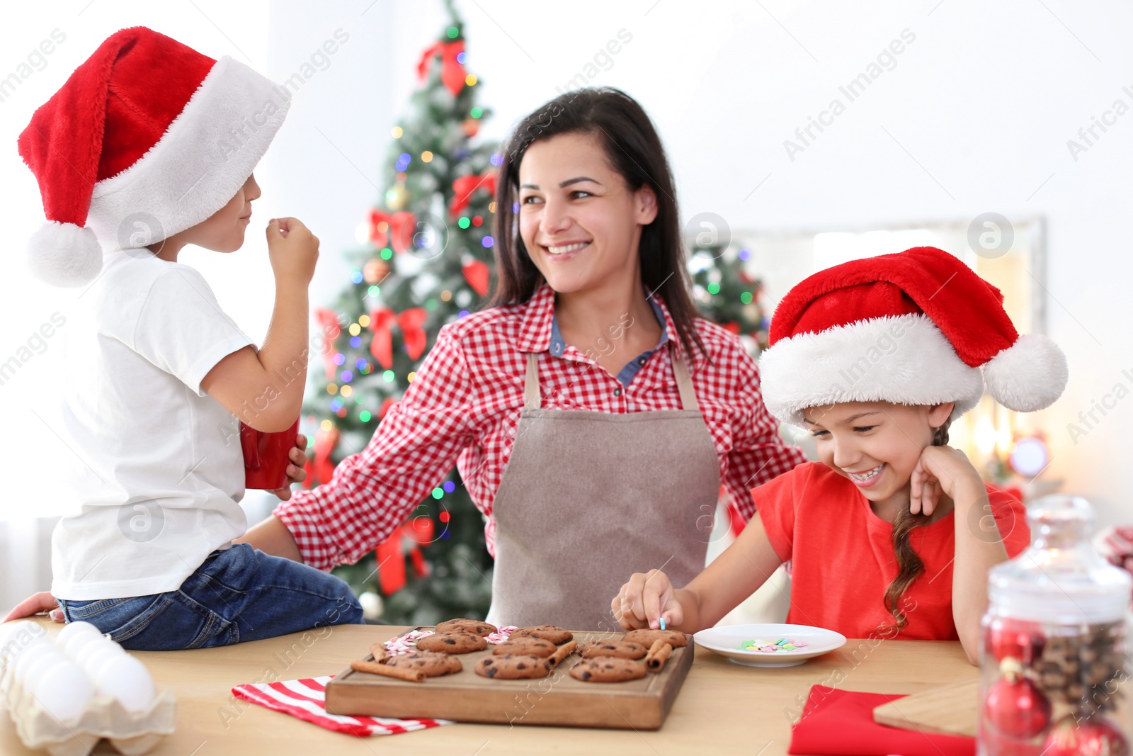 Photo of Mother and children making Christmas cookies together at home