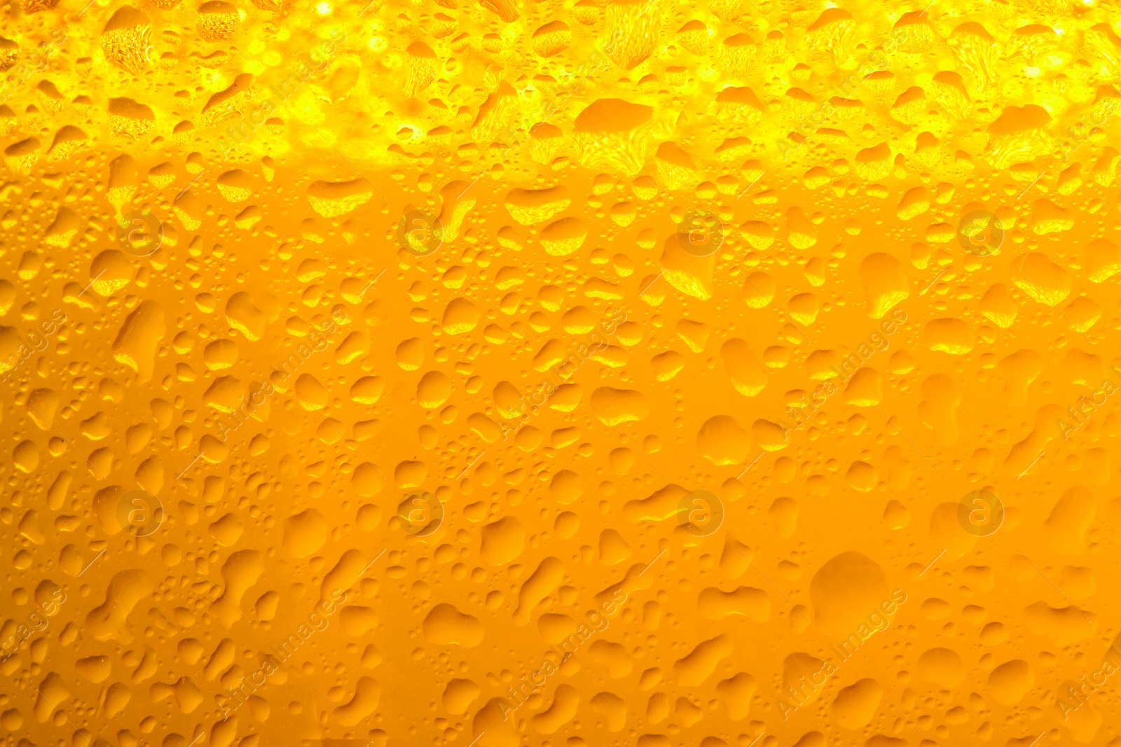 Photo of Glass of tasty cold beer with condensation drops as background, closeup