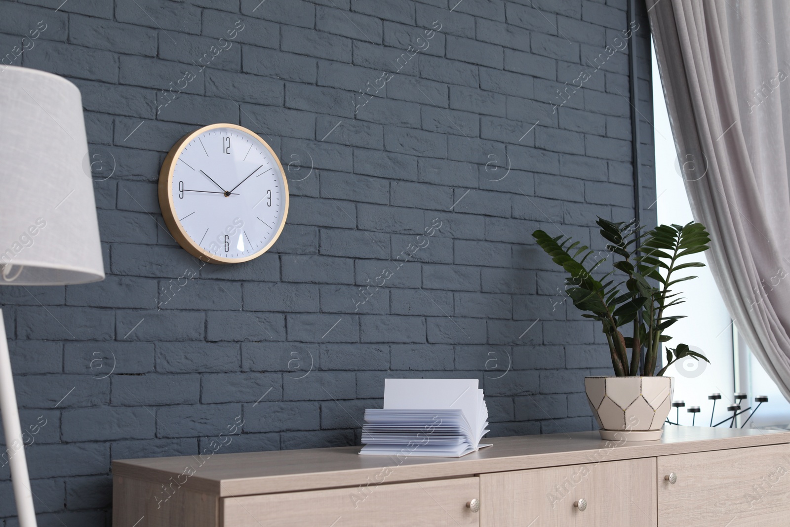 Photo of Stylish room interior with wall clock. Time of day