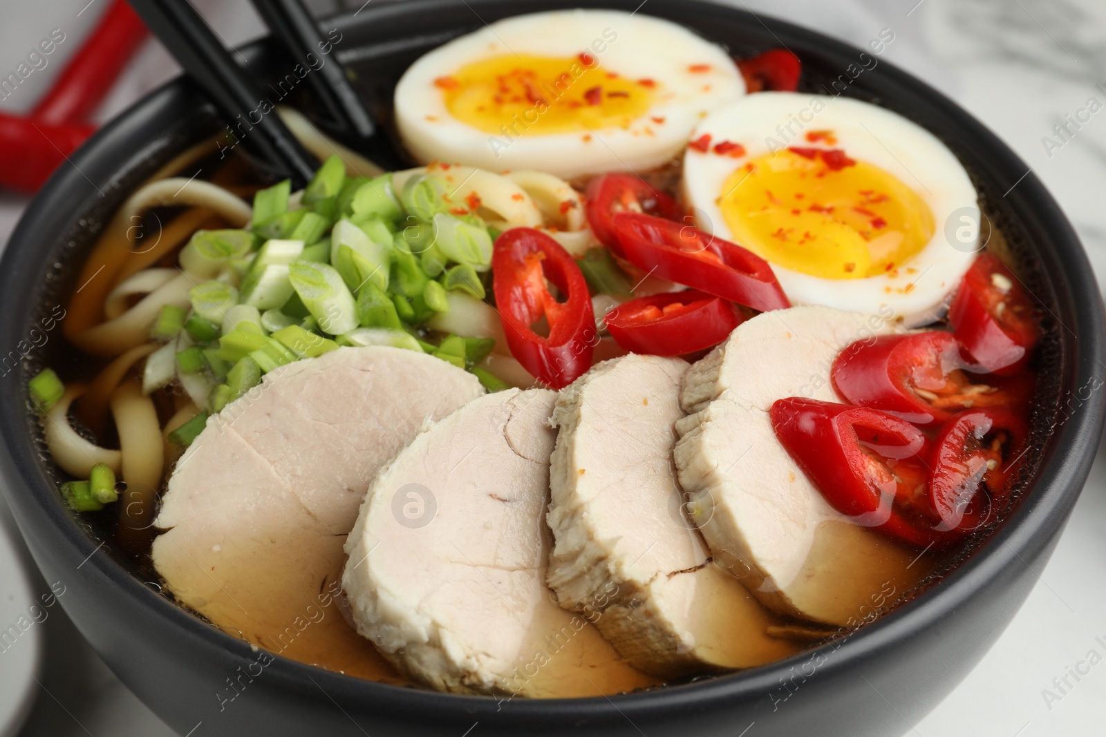 Photo of Delicious ramen in bowl on table, closeup. Noodle soup