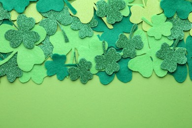 St. Patrick's day. Decorative clover leaves on green background, top view. Space for text