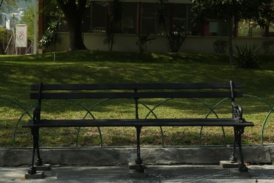 Beautiful old black bench near pathway in park