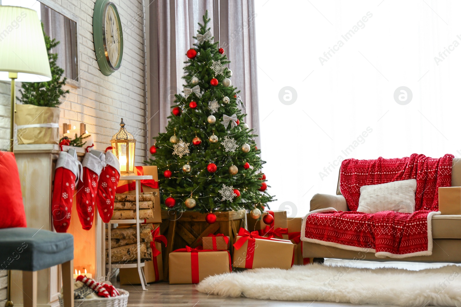 Photo of Stylish interior with beautiful Christmas tree and decorative fireplace