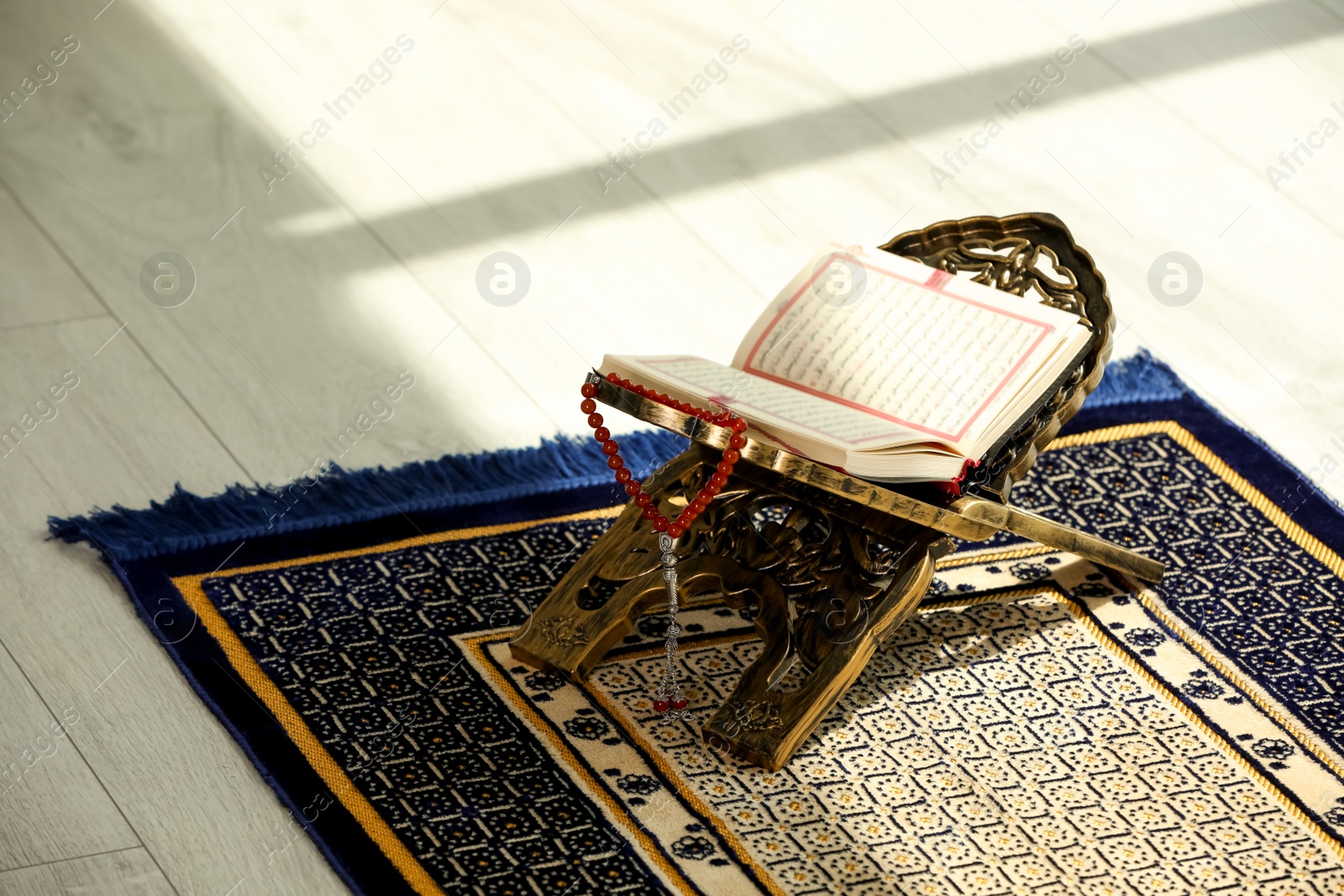 Photo of Rehal with open Quran and Misbaha on Muslim prayer rug indoors, space for text