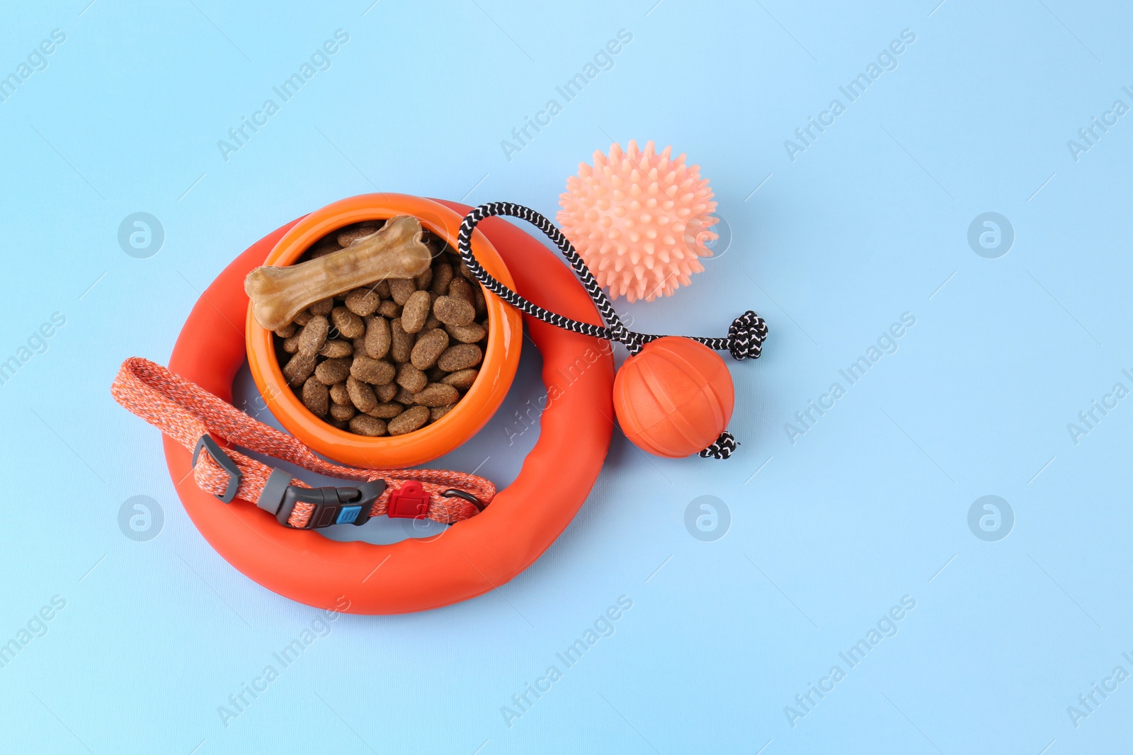 Photo of Dry pet food and toys on light blue background, flat lay with space for text. Shop items