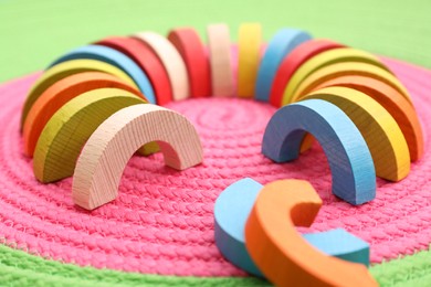 Colorful wooden pieces of playing set on color mat, closeup. Educational toy for motor skills development