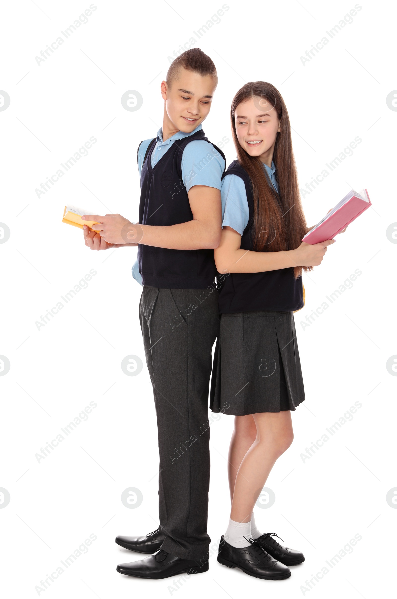 Photo of Full length portrait of teenagers in school uniform with books on white background