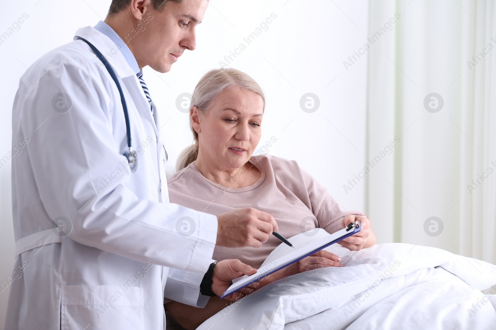 Photo of Doctor visiting his patient in hospital ward