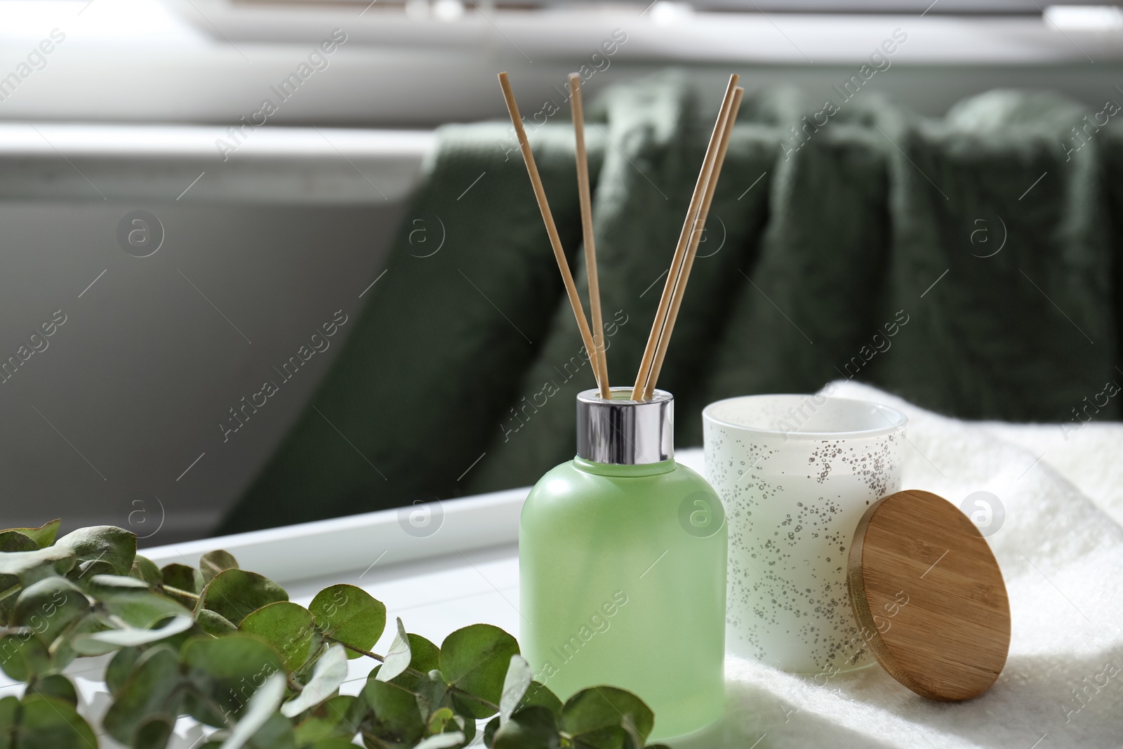 Photo of Reed air freshener and eucalyptus branches on tray indoors