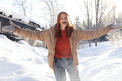Photo of Emotional woman playing with snow outdoors. Winter vacation