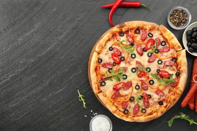 Tasty pizza and ingredients on grey table, top view. Space for text