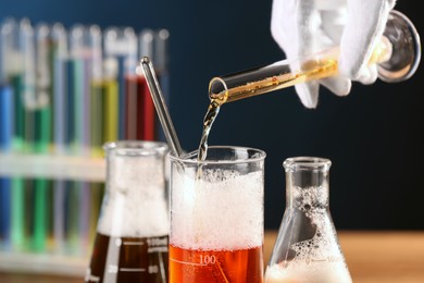 Scientist working with laboratory glassware indoors, closeup. Chemical reaction