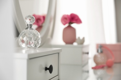 Photo of Bottle of perfume on white dressing table