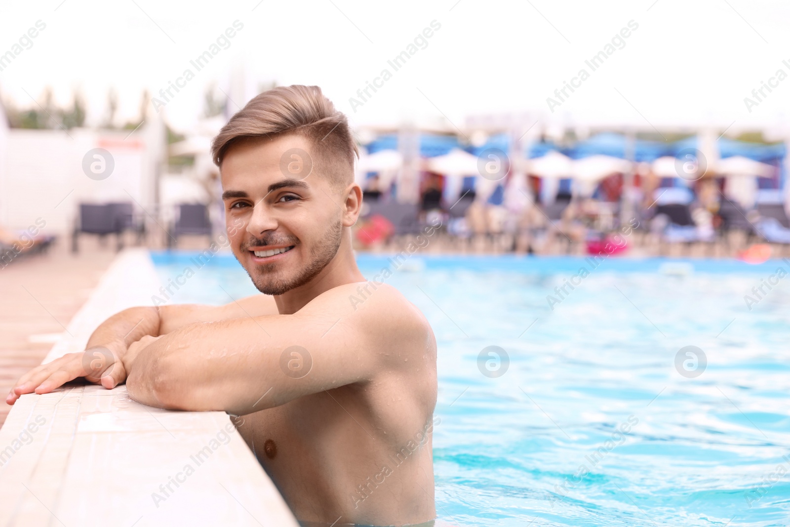 Photo of Young man in pool on sunny day